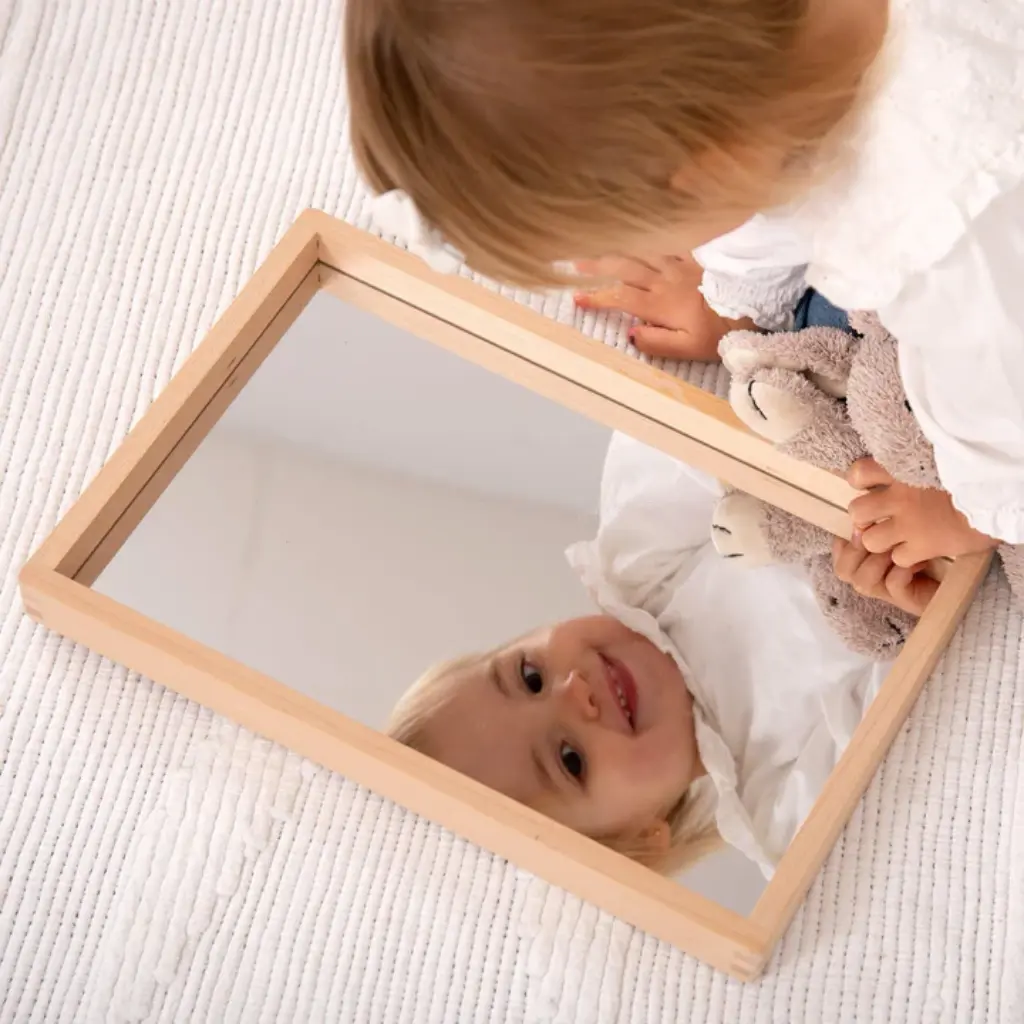 Niña-descubriendo-con-Tickit-Pequeña-bandeja-espejo-de-madera-Lanzarote.webp