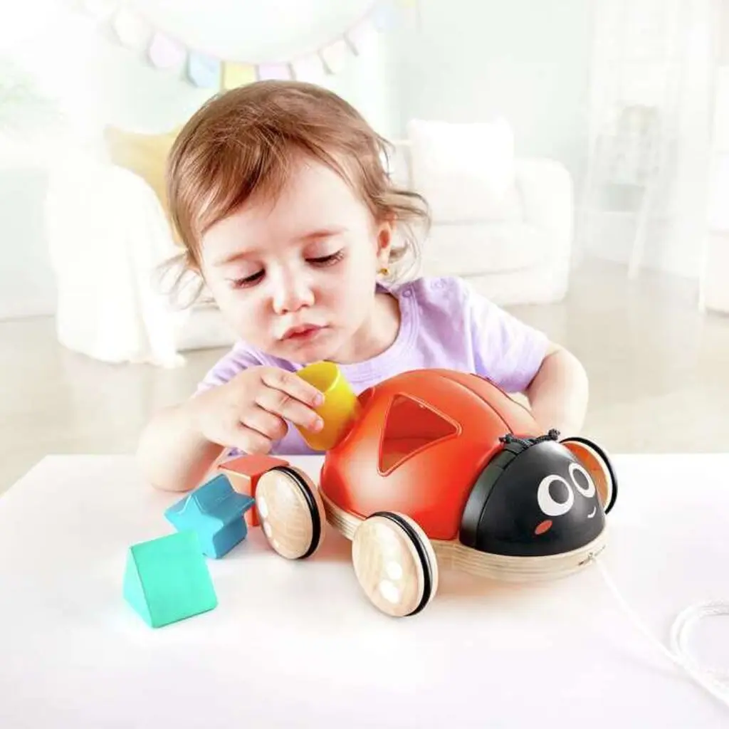 E0364-niña-jugando-con-mariquita-clasificadora-de-formas-hape-jugueteria-mukkies.webp