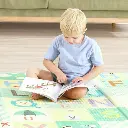 Nino-Leyendo-sobre-Alfombra-Foldable-Alfabeto-Hape.webp