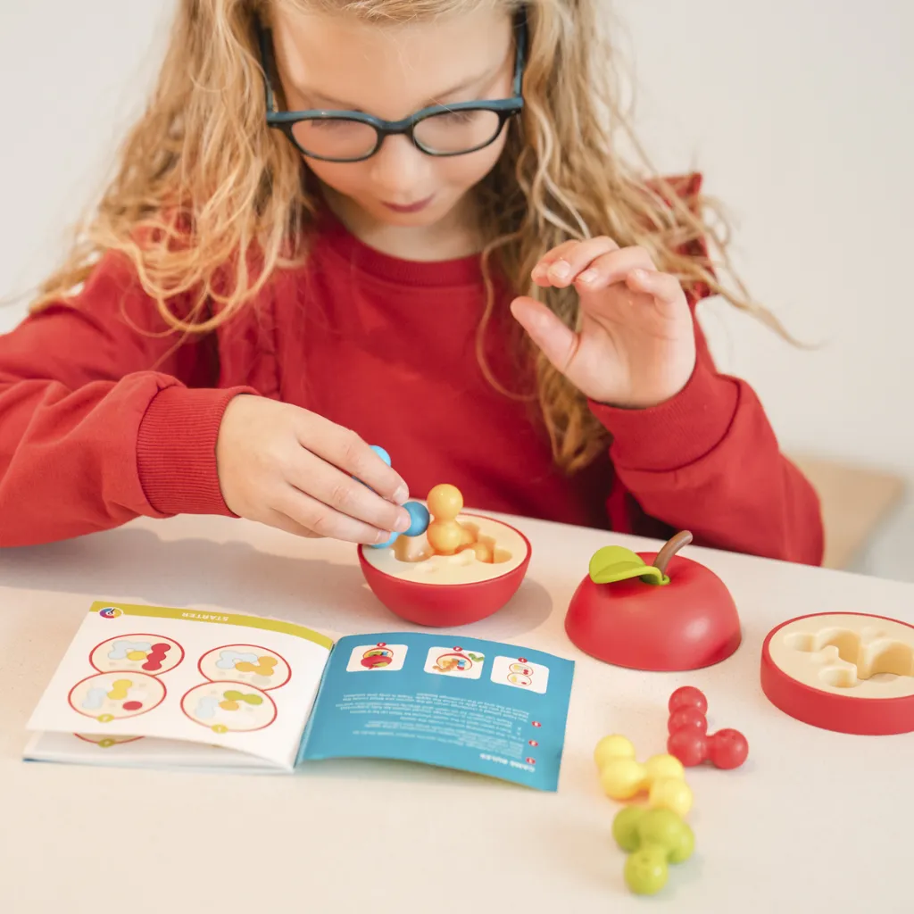 SG417-Niña-jugando-con-Juego-de-logica-Apple-Puzzler-SmartGames-Jugueteria-Lanzarote.webp