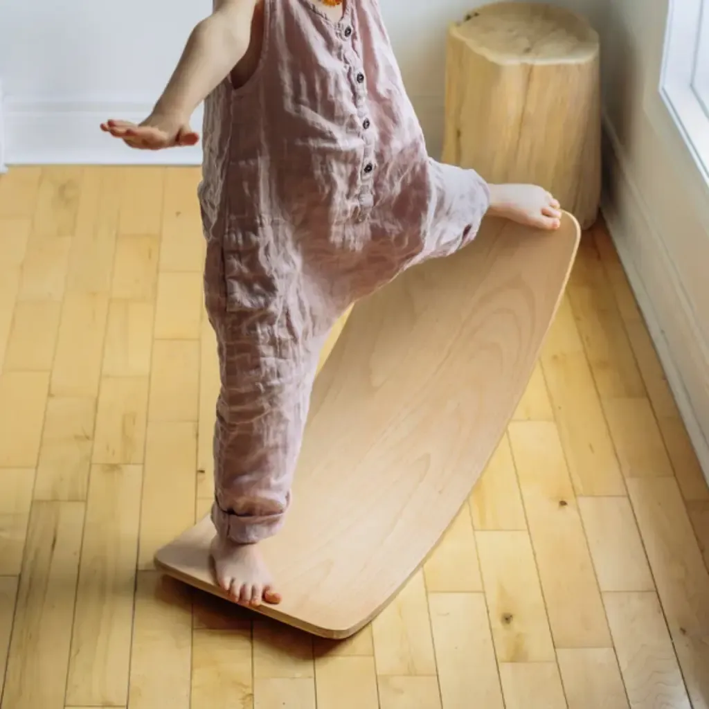 Niña sobre Tabla Curva Kinderboard-Kinderfeets-desarrolla el equilibrio.webp